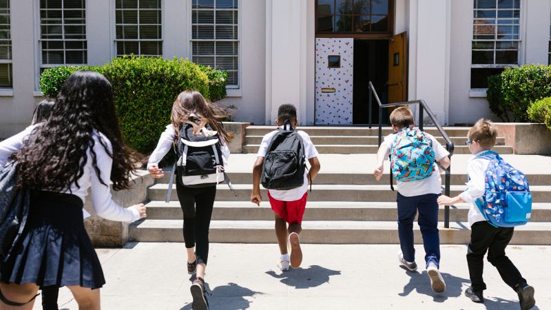 rentrée scolaire enfants avec cartable qui courent vers lécole